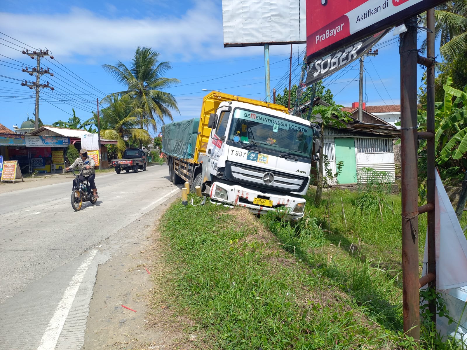 Terlambat Mengerem, Truk Bermuatan Semen Tubruk Tiang Baliho di Jalan Raya Kesugihan