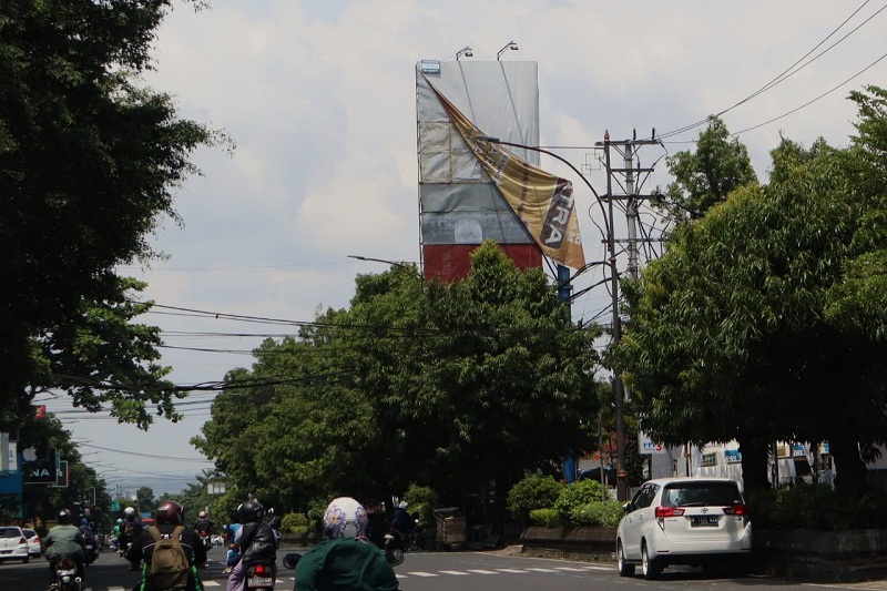 Baliho Terkelupas di Jalan Jenderal Sudirman Purwokerto Bahayakan Pengguna Jalan