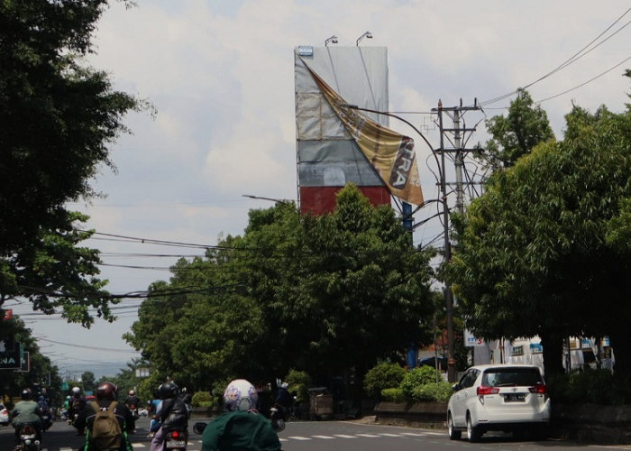 Baliho Terkelupas di Jalan Jenderal Sudirman Purwokerto Bahayakan Pengguna Jalan