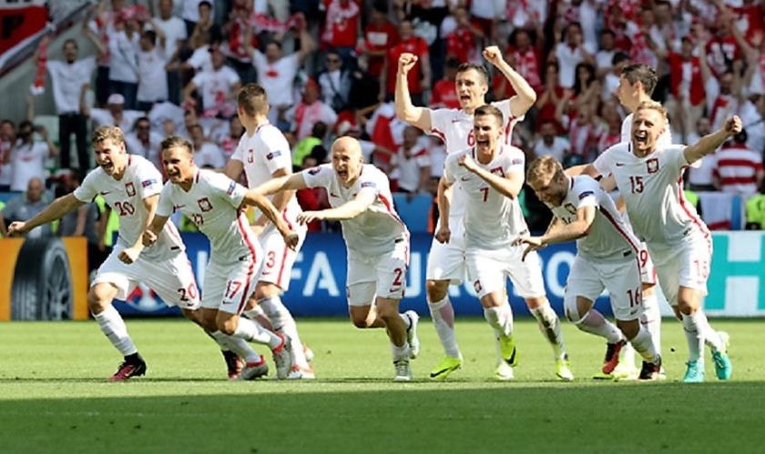 Poland's players celebrate their team's win in the Euro 2016 round of sixteen football match between Switzerland and Poland at the Geoffroy-Guichard stadium in Saint-Etienne on June 25, 2016. / AFP PHOTO / Valery HACHE